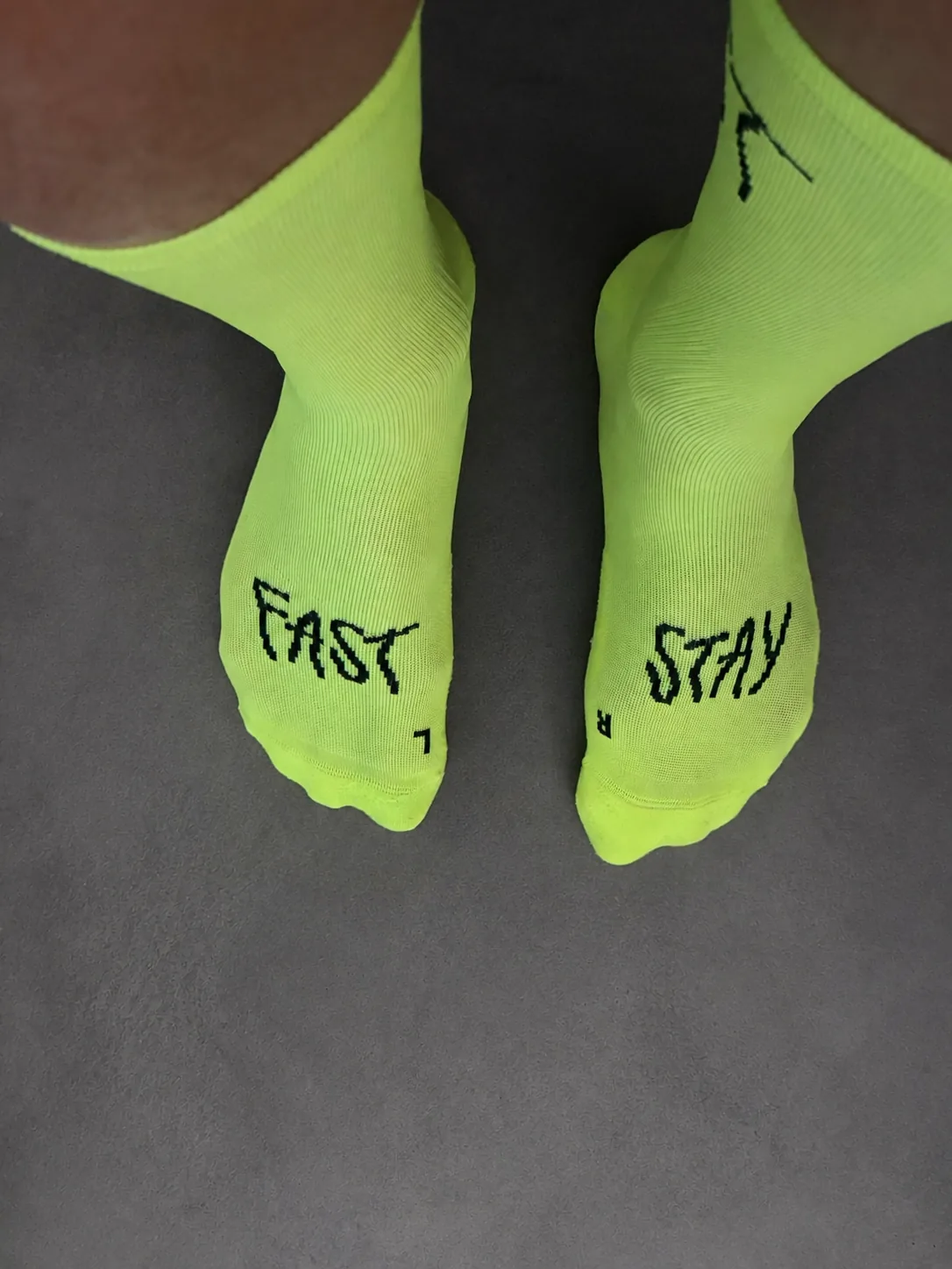 Calcetines de running Pacific & Co. en color amarillo neón con las palabras FAST y STAY