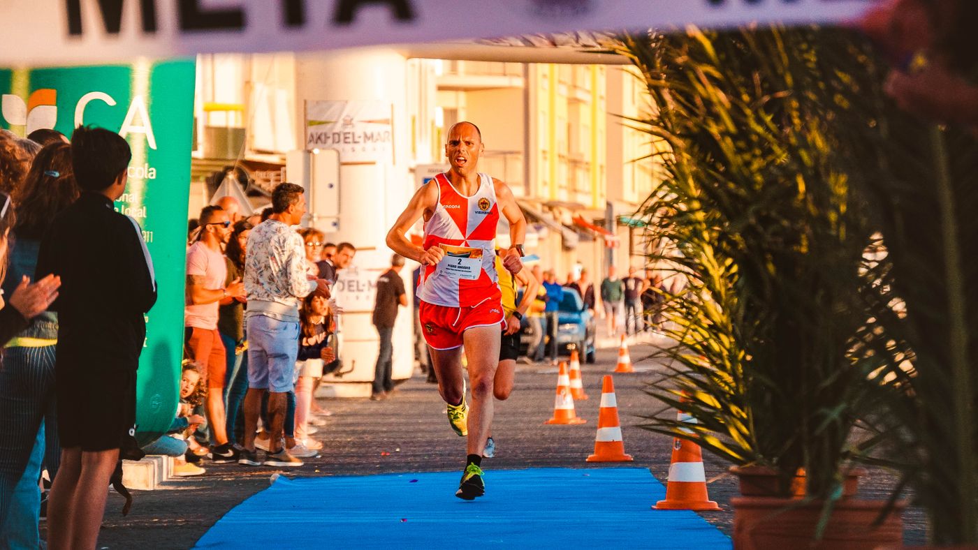Ambiente en la zona de meta de una media maratón, con público animando a los corredores