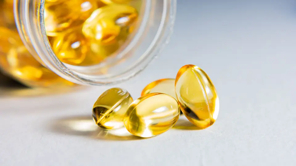 Cápsulas blandas de omega-3 saliendo de un frasco