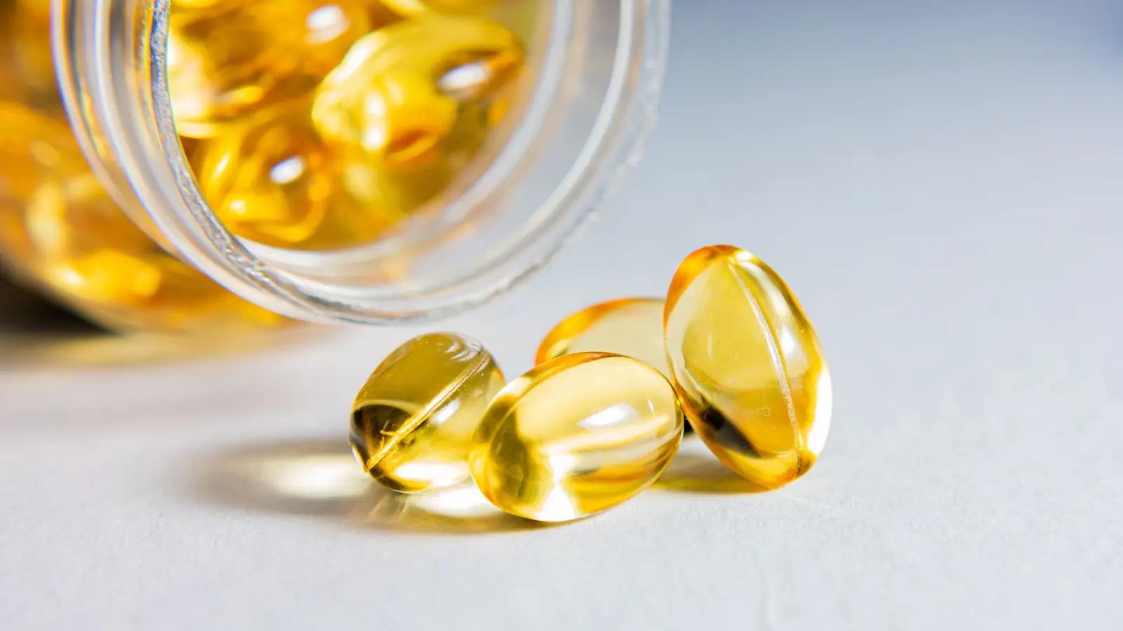 Cápsulas blandas de omega-3 saliendo de un frasco