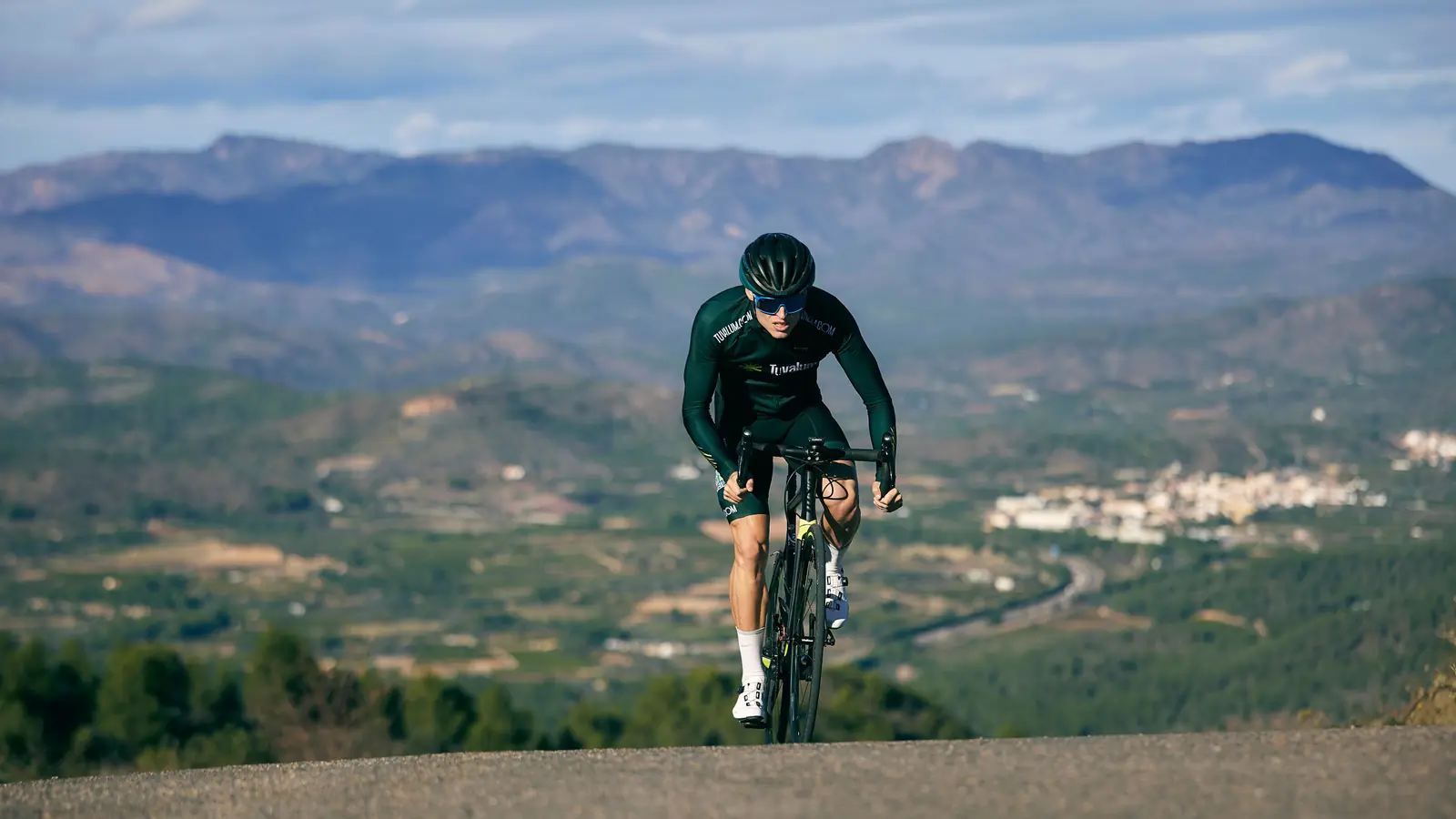 Ciclista con casco subiendo un puerto de montaña a ritmo constante