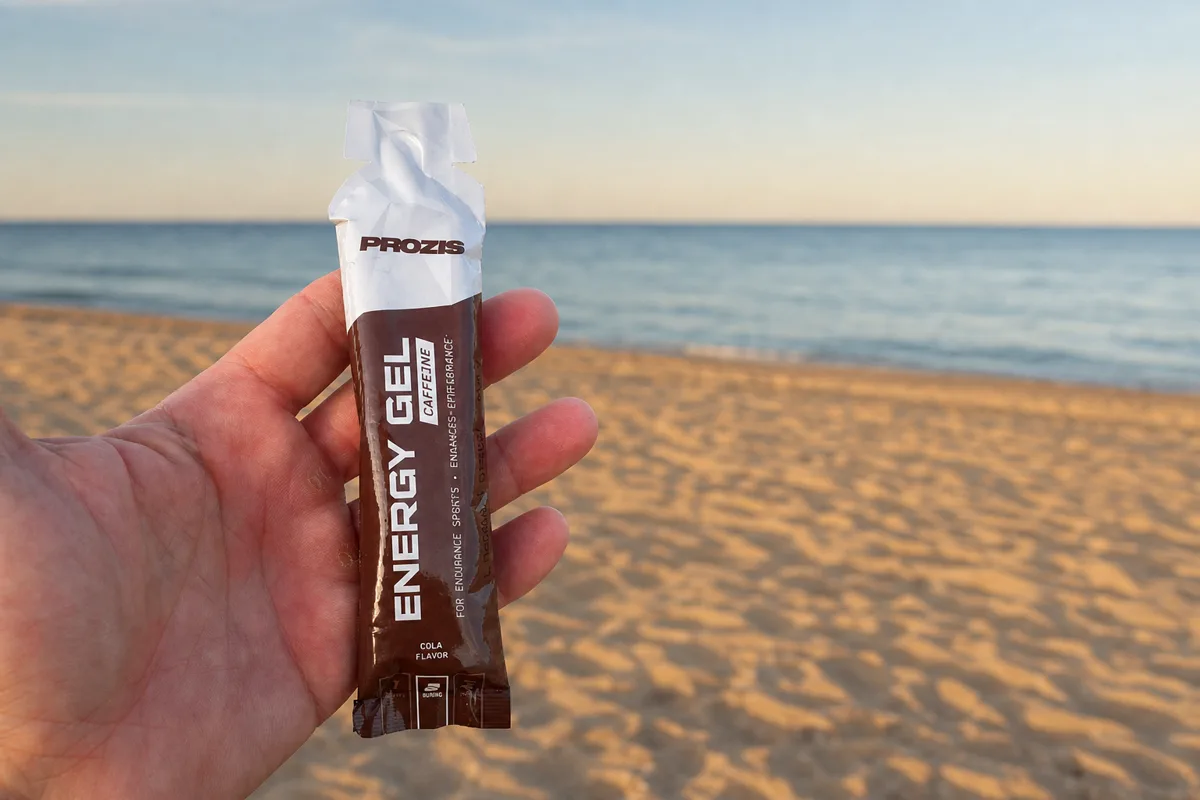 Sobre de Prozis Energy Gel+ Cafeína sabor Cola, de 50 gramos, sostenido en la mano