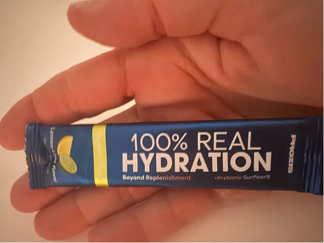 Stick de Prozis 100% Real Hydration sabor Lima-Limón sostenido en la mano