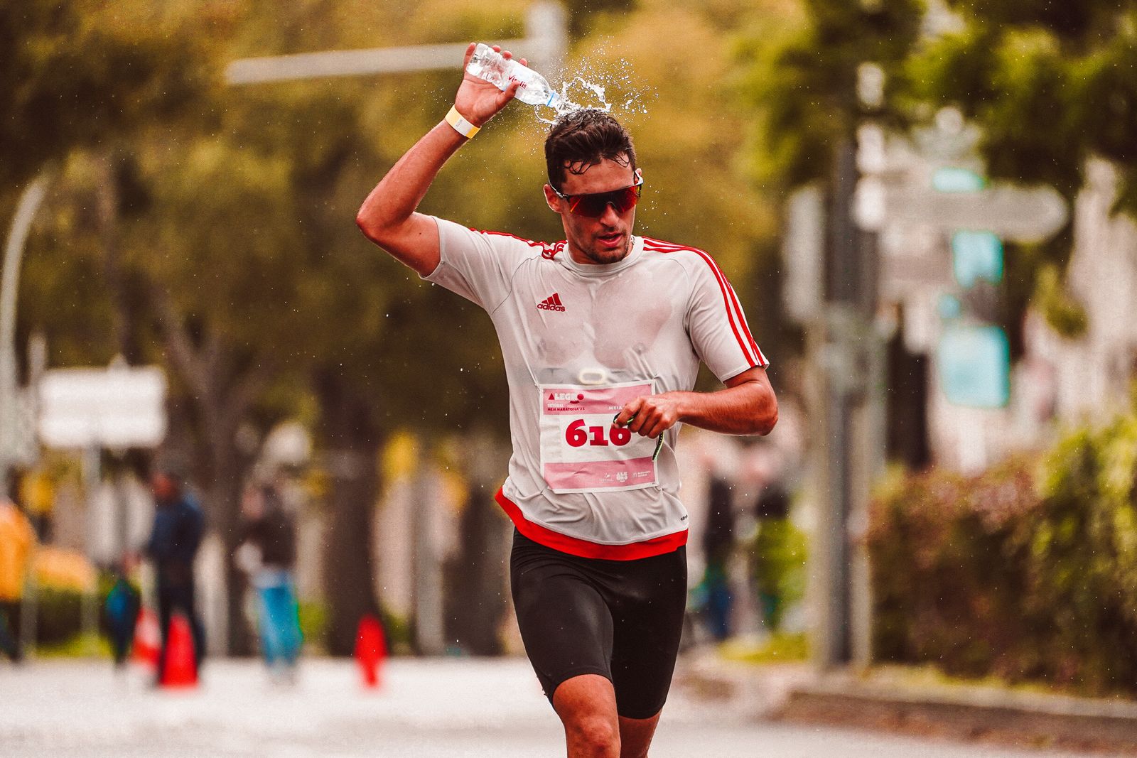 Corredor refrescándose con agua durante una carrera con calor