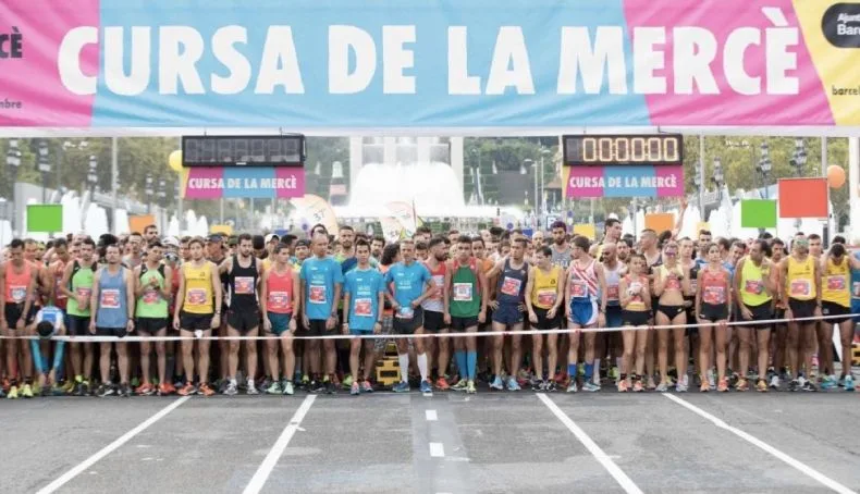 Salida de la Cursa de la Mercè - corredores en la línea de salida con el banner oficial