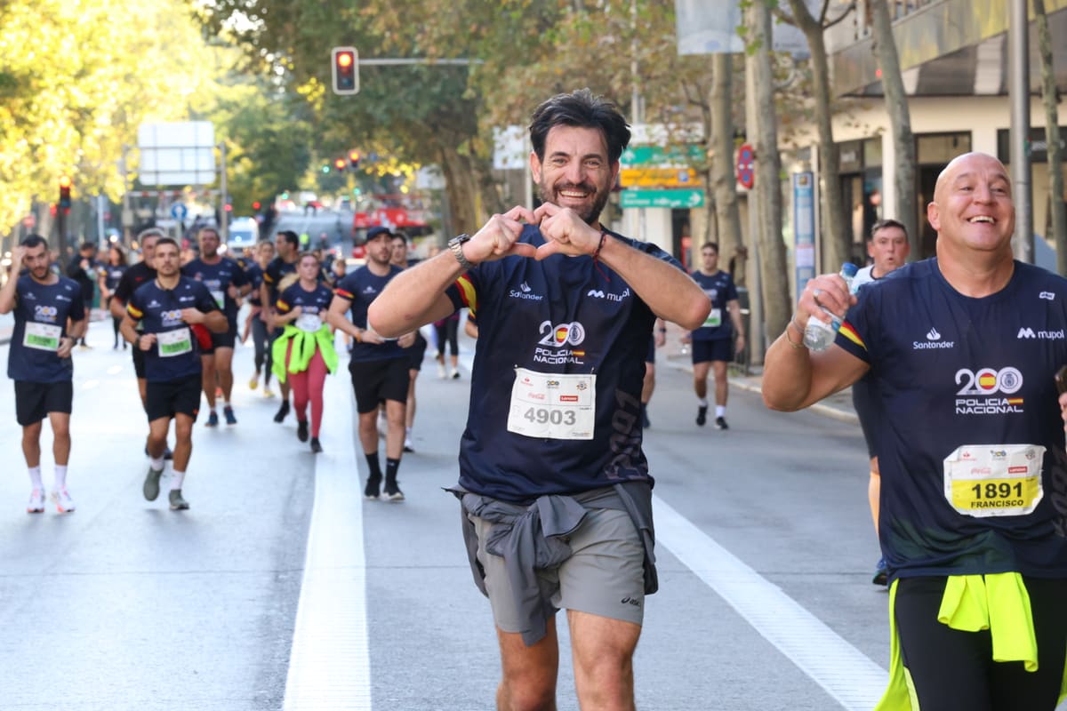 Corredores sonrientes haciendo el gesto de un corazón durante la carrera Ruta 091 de Madrid