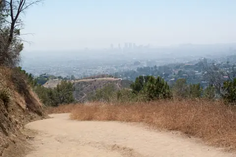 Sendero de tierra en Griffith Park con Los Ángeles al fondo