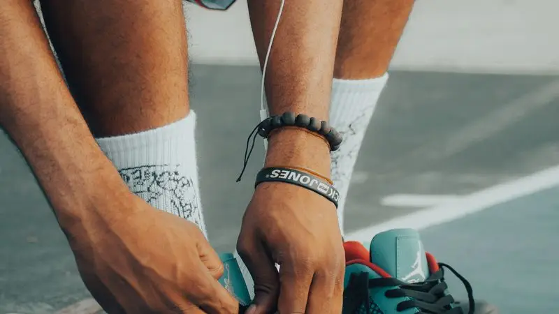 Primer plano de manos atando los cordones de unas zapatillas de running