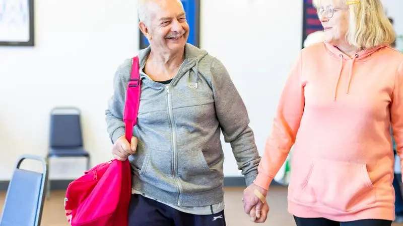 Pareja de adultos mayores sonriendo en un gimnasio