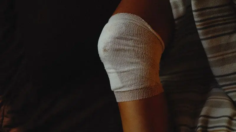 Rodilla vendada con gasa medica tras una lesion deportiva