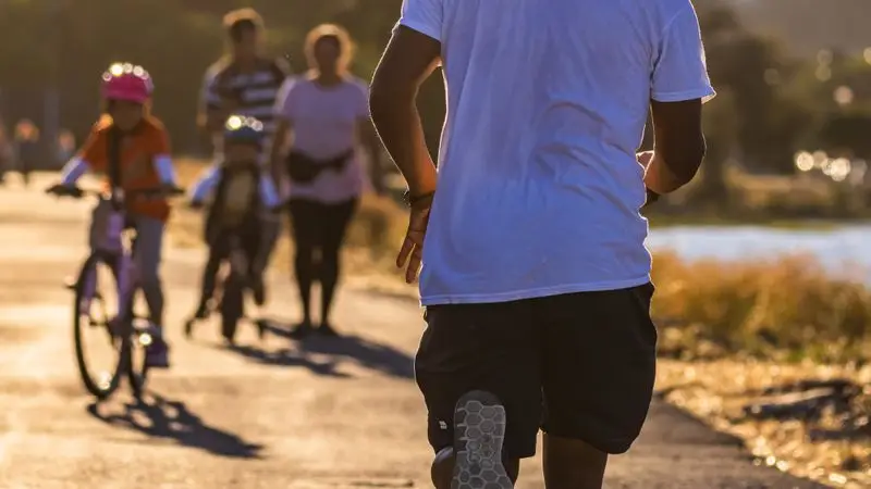 Hombre corriendo al amanecer en pista de atletismo al aire libre