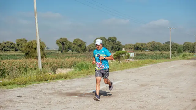 Corredor principiante entrenando a ritmo suave por un camino rural
