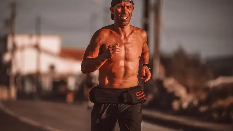 Corredor adulto con expresion de esfuerzo durante una carrera de maraton urbana