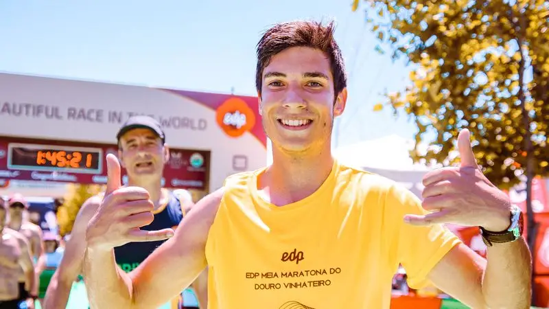 Runner sonriendo y celebrando al cruzar la meta de una carrera