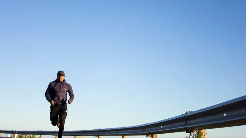 Runner entrenando para media maratón sub 2 horas en una pista de atletismo