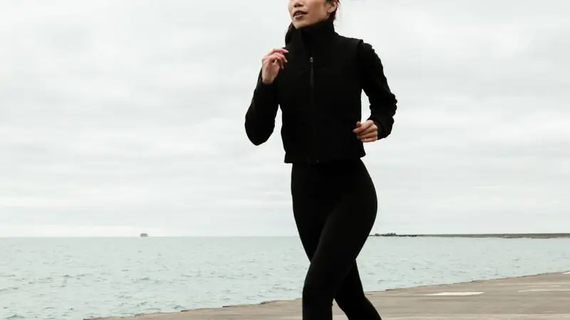 Mujer haciendo jogging junto al paseo maritimo