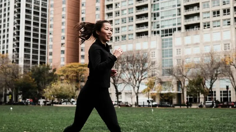 Mujer haciendo jogging en pista urbana durante el otono