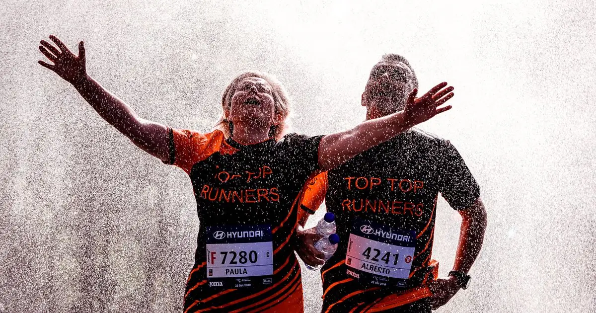 Runners hidrat&aacute;ndose durante una carrera popular