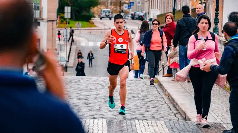 Corredor con dorsal compitiendo en carrera popular por la ciudad