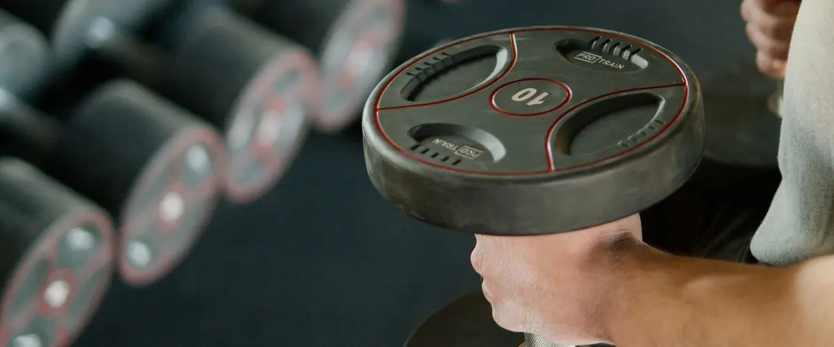 Corredor haciendo ejercicios de fuerza de piernas en el gimnasio