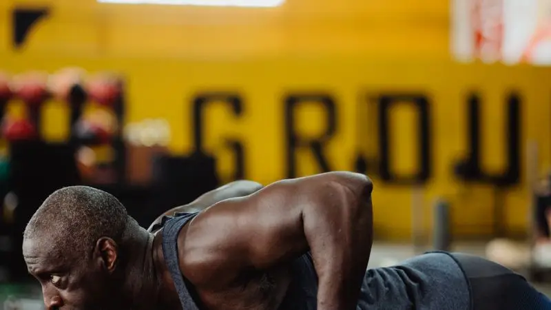 Atleta realizando ejercicio de fuerza con kettlebells en el gimnasio