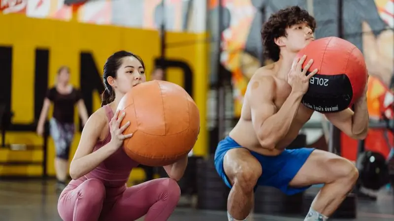 Atleta realizando lanzamiento de bal&oacute;n medicinal contra la pared