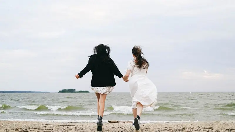 Pareja corriendo junta por la playa junto al mar