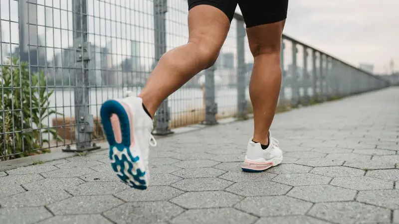 Piernas de corredor haciendo jogging al aire libre con zapatillas deportivas