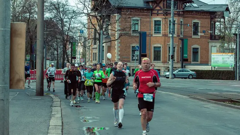 Grupo de runners corriendo por las calles de una ciudad europea durante una carrera popular