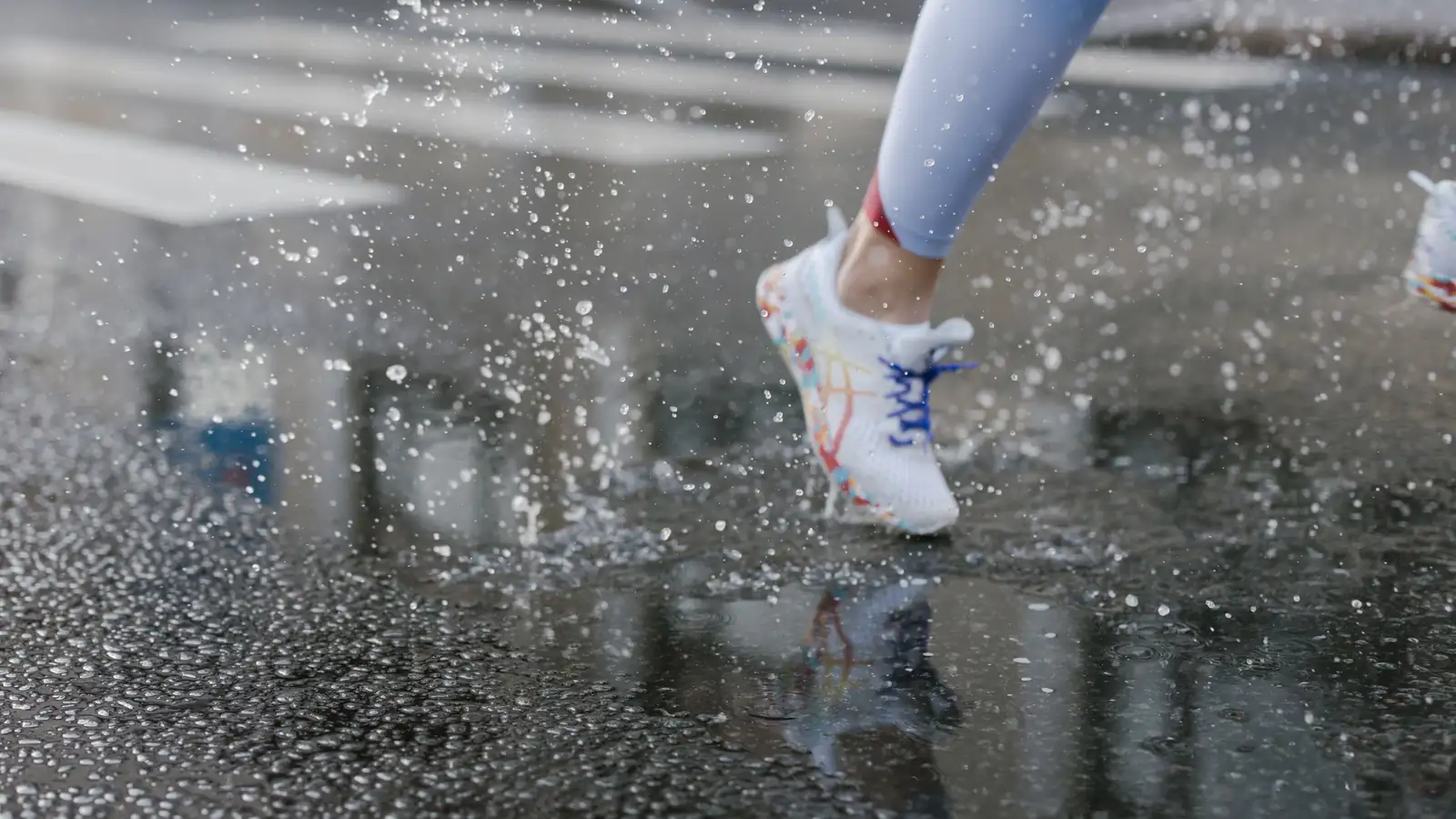 Zapatilla de running pisando un charco y levantando salpicaduras de agua