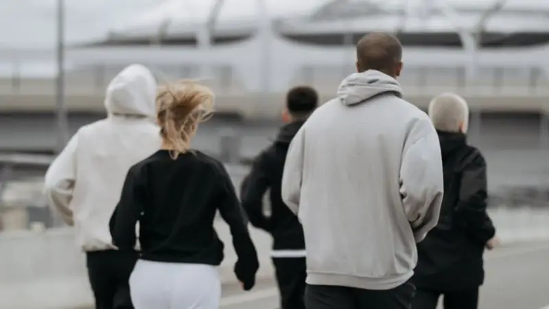 Five adults jogging together outdoors