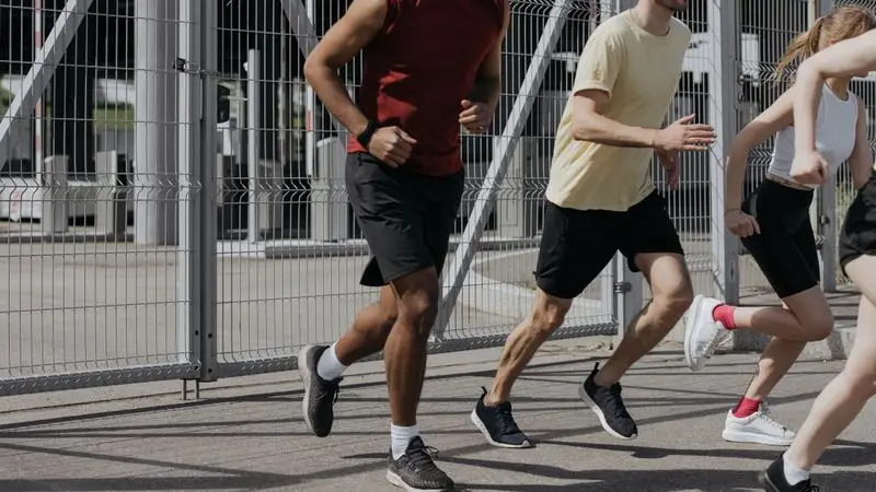 Grupo de runners adultos corriendo juntos por la ciudad