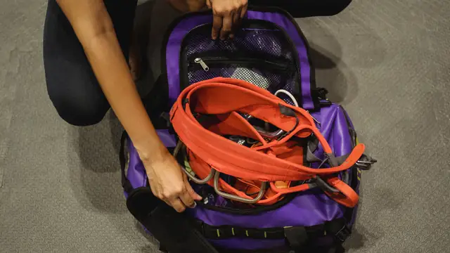Vista cenital de una mochila deportiva abierta mientras se guarda material de entrenamiento
