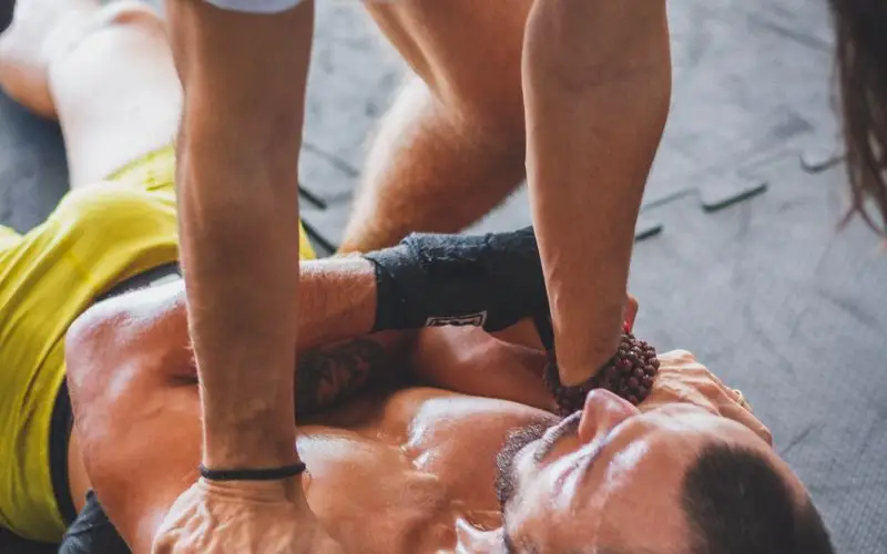 Deportista usando foam roller para masaje muscular de recuperaci&oacute;n