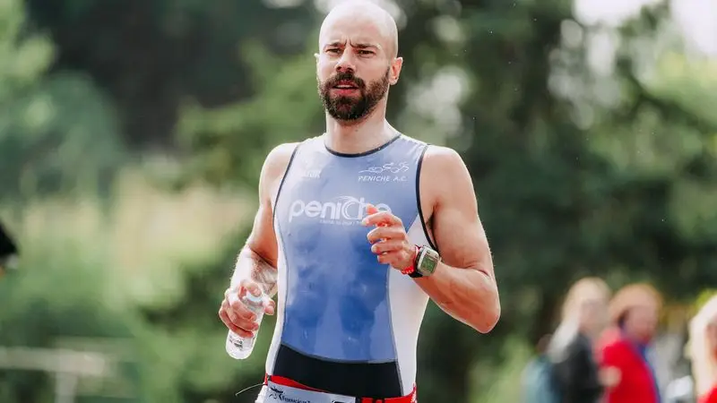 Corredor con botella de agua durante una competici&oacute;n de running