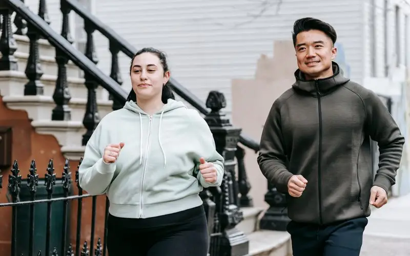 Runner with diabetes training outdoors with monitoring technology