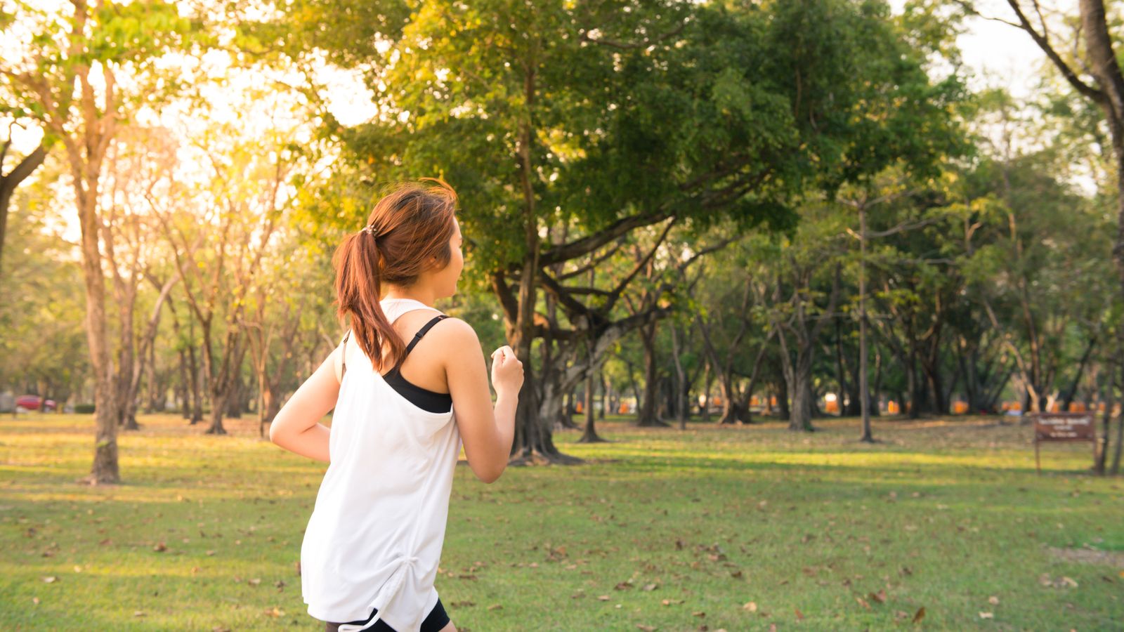 Persona empezando a correr en un parque al atardecer