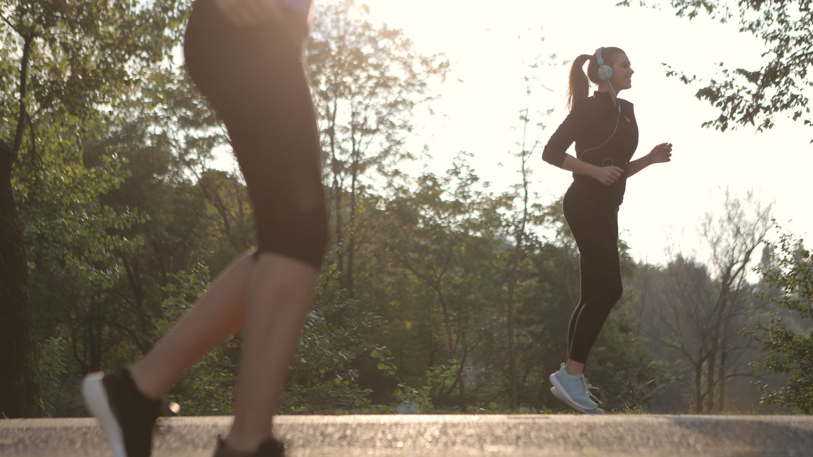 Dos personas corriendo en un parque al amanecer